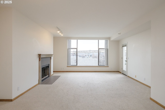 unfurnished living room featuring track lighting and light carpet