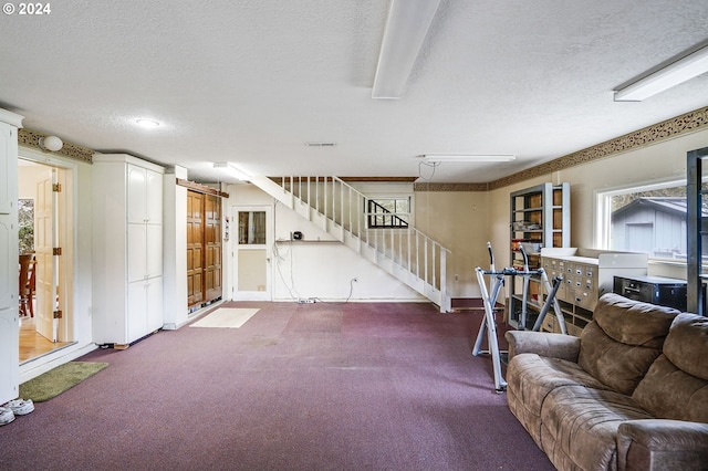 carpeted living room featuring a barn door and a textured ceiling