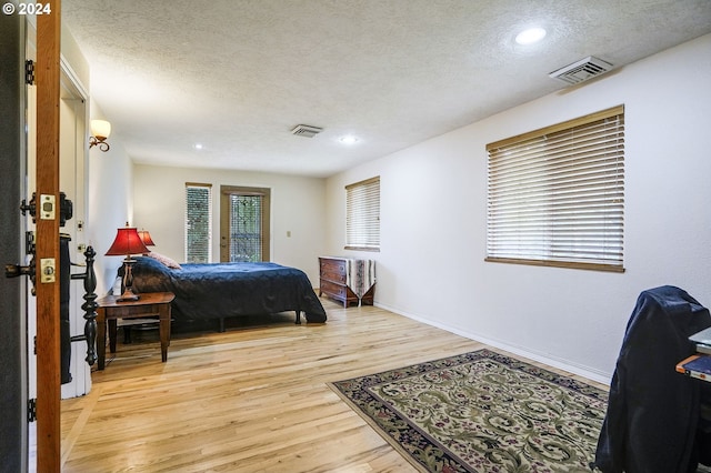 bedroom featuring a textured ceiling and light wood-type flooring