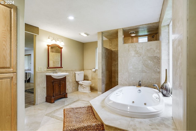 bathroom featuring tile flooring, vanity, toilet, and tile walls