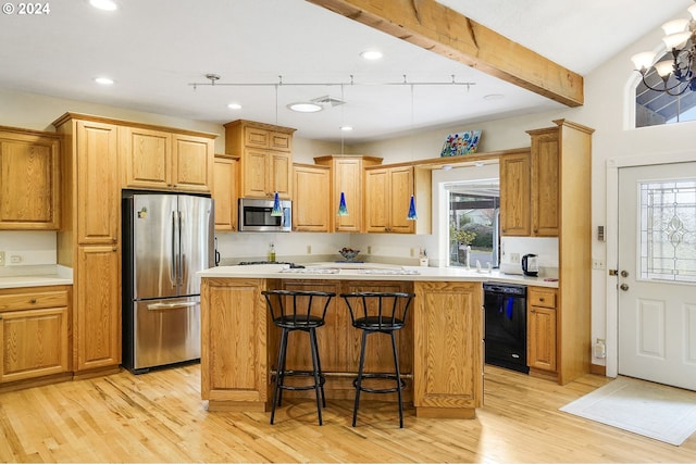 kitchen with a kitchen bar, appliances with stainless steel finishes, a kitchen island, light hardwood / wood-style floors, and beamed ceiling