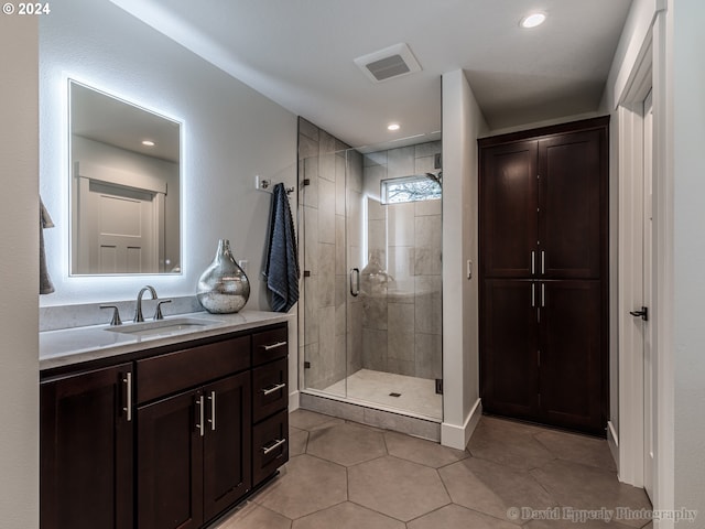 bathroom featuring tile floors, vanity, and a shower with shower door