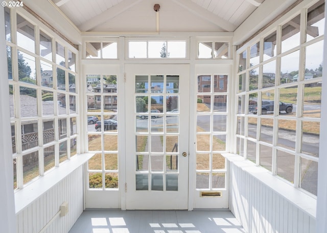 unfurnished sunroom featuring lofted ceiling with beams and wooden ceiling