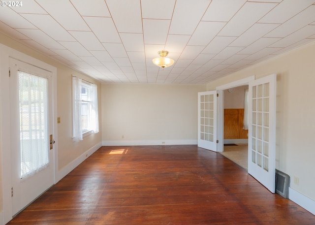 unfurnished room featuring french doors, ornamental molding, and dark hardwood / wood-style flooring