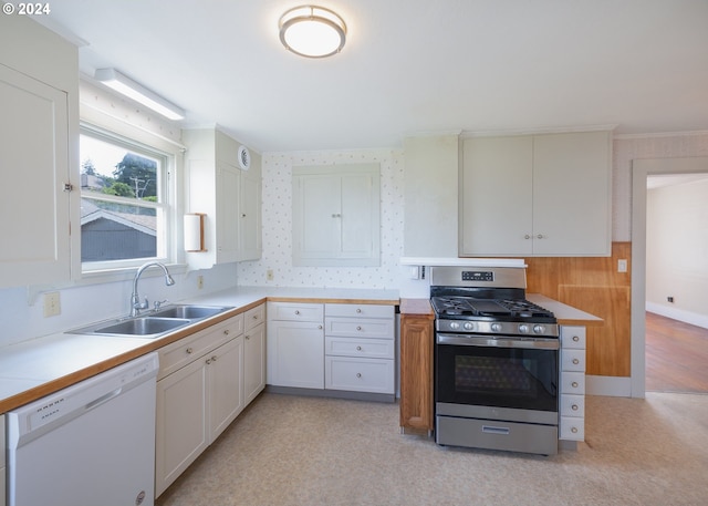 kitchen with white cabinets, white dishwasher, gas range, light colored carpet, and sink