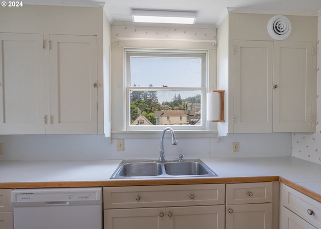 kitchen with white dishwasher, sink, and white cabinetry