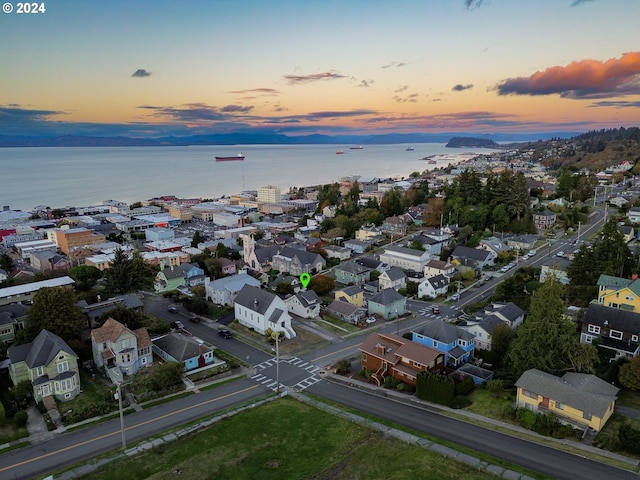 aerial view at dusk featuring a water view