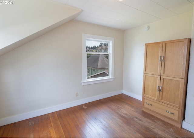 additional living space featuring lofted ceiling and dark hardwood / wood-style floors