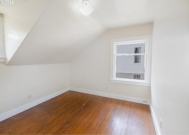 additional living space featuring lofted ceiling and dark hardwood / wood-style flooring