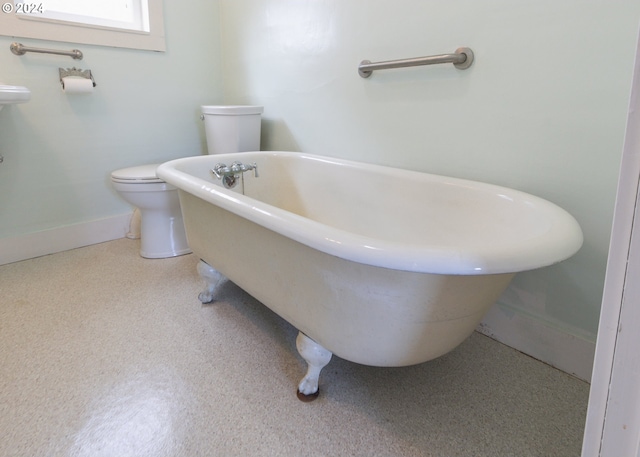 bathroom featuring a tub to relax in and toilet