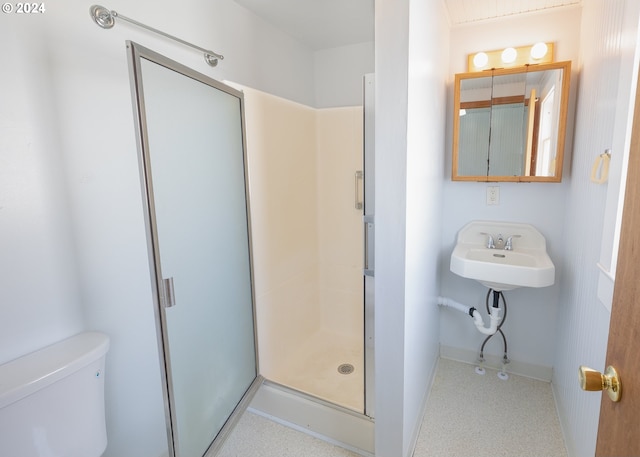 bathroom featuring toilet, an enclosed shower, and sink