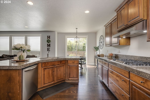 kitchen featuring pendant lighting, dark hardwood / wood-style flooring, sink, a textured ceiling, and stainless steel appliances