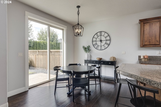 dining space with an inviting chandelier and dark hardwood / wood-style floors