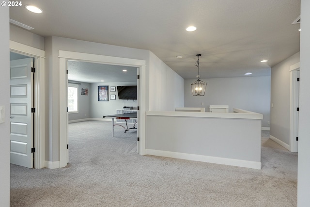 carpeted empty room featuring a chandelier