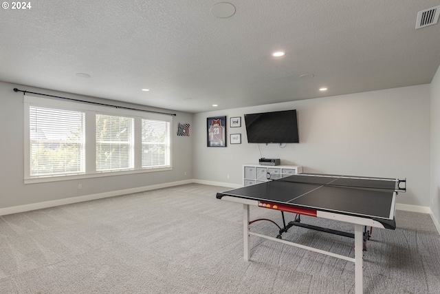 game room featuring light colored carpet and a textured ceiling