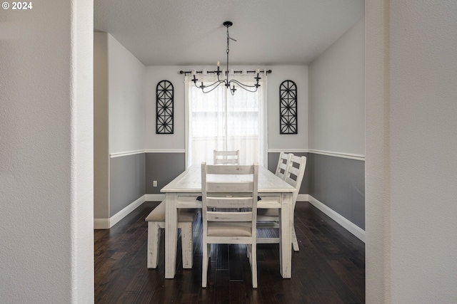 dining area with a textured ceiling, an inviting chandelier, and dark hardwood / wood-style floors