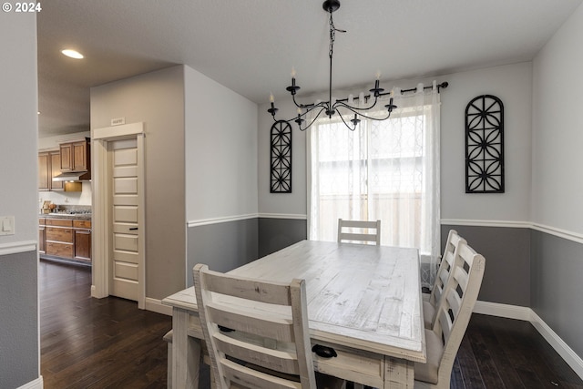 dining area featuring dark hardwood / wood-style flooring and a chandelier