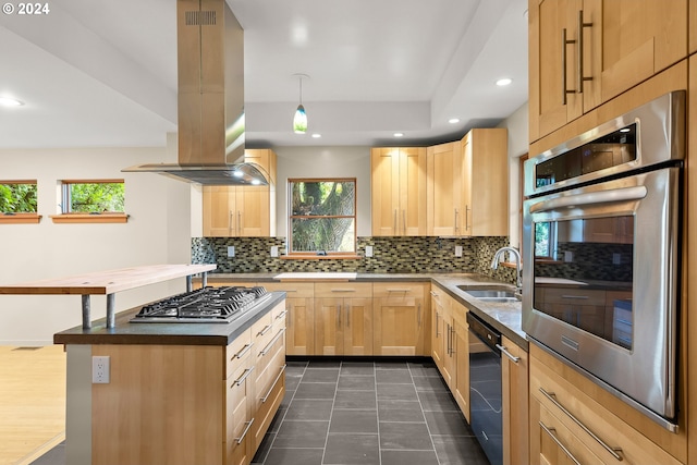 kitchen with island exhaust hood, stainless steel appliances, sink, pendant lighting, and light brown cabinetry