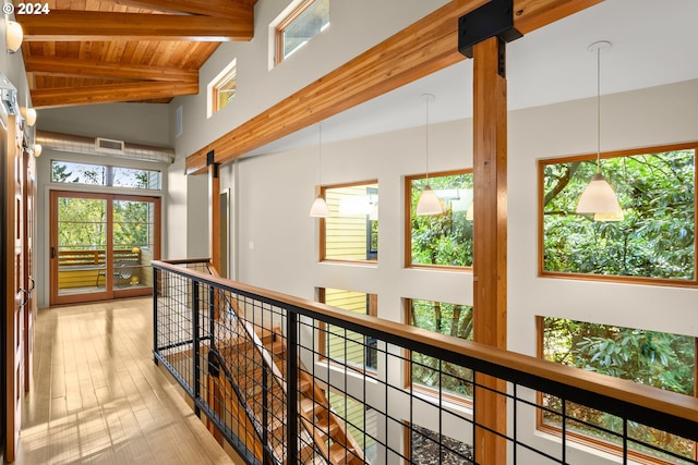 hall with lofted ceiling with beams, wooden ceiling, light hardwood / wood-style flooring, and a barn door