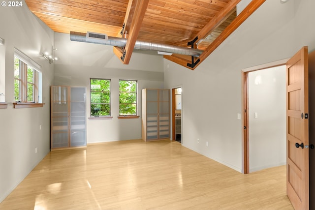 spare room with beam ceiling, light wood-type flooring, high vaulted ceiling, and wooden ceiling