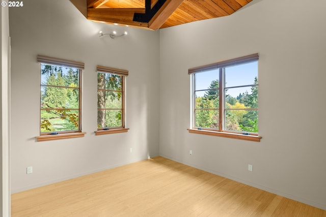 spare room with wooden ceiling, beamed ceiling, and light wood-type flooring