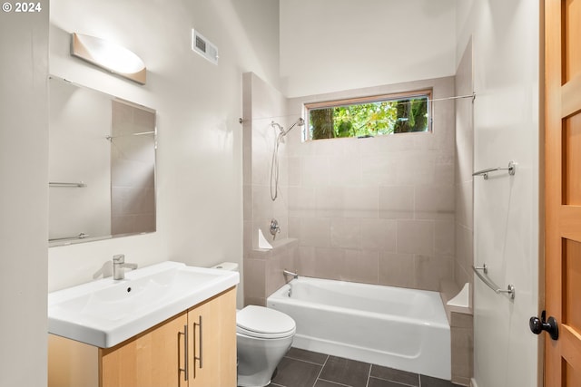 full bathroom with vanity, tiled shower / bath combo, toilet, and tile patterned floors