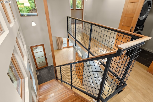 staircase with hardwood / wood-style floors and a high ceiling