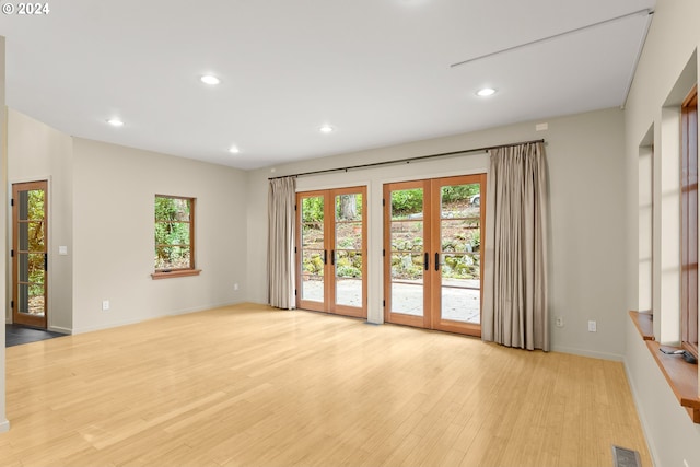 empty room with light hardwood / wood-style flooring and french doors