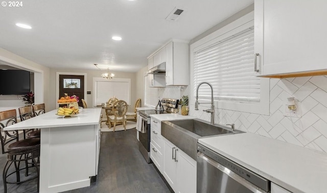 kitchen with white cabinets, stainless steel appliances, dark hardwood / wood-style floors, and tasteful backsplash