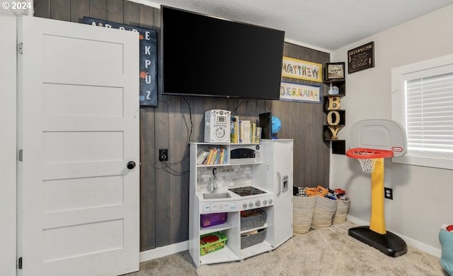 recreation room featuring carpet and wooden walls