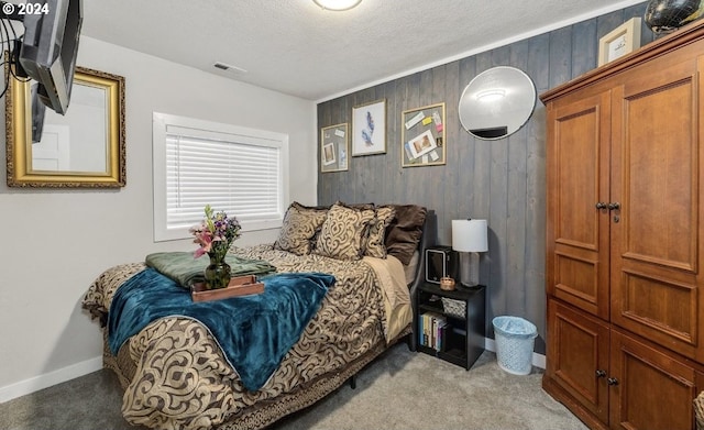 carpeted bedroom featuring wood walls and a textured ceiling