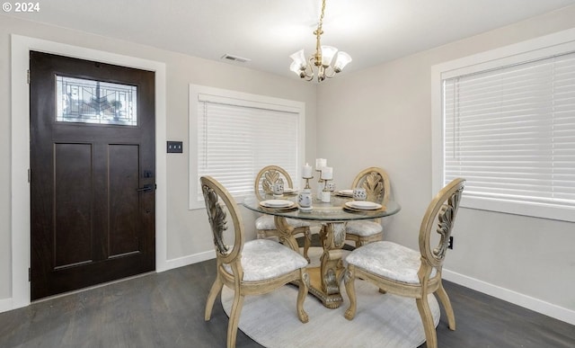 dining space with a chandelier and dark hardwood / wood-style flooring