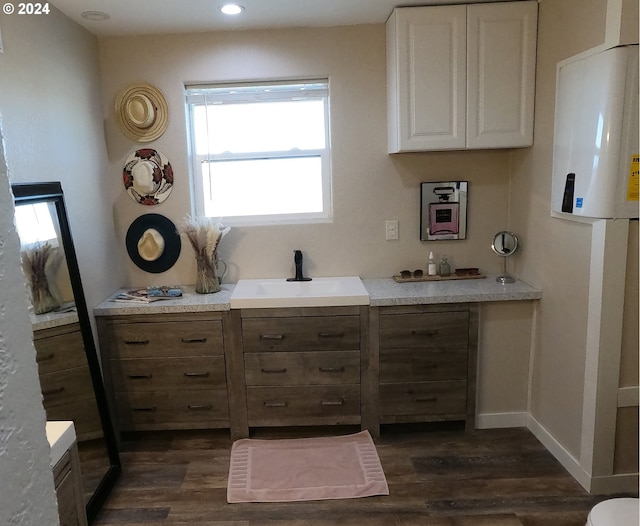 interior space with dark hardwood / wood-style flooring, sink, and white cabinets