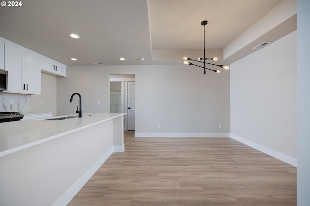 20542 Empire Ave, Bend, OR 97701 - kitchen featuring recessed lighting, a sink, white cabinetry, baseboards, and a chandelier