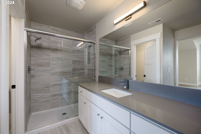 bathroom with vanity and a shower with door