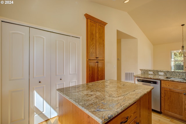 kitchen with light stone counters, dishwasher, a kitchen island, and lofted ceiling