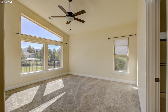 carpeted spare room with ceiling fan and vaulted ceiling