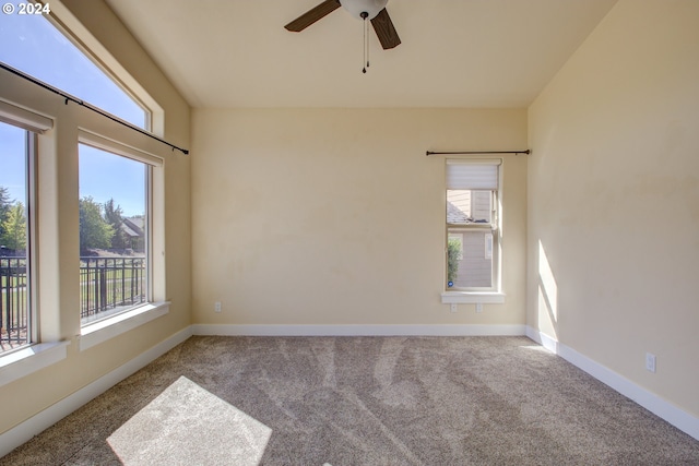 carpeted spare room featuring ceiling fan and a healthy amount of sunlight