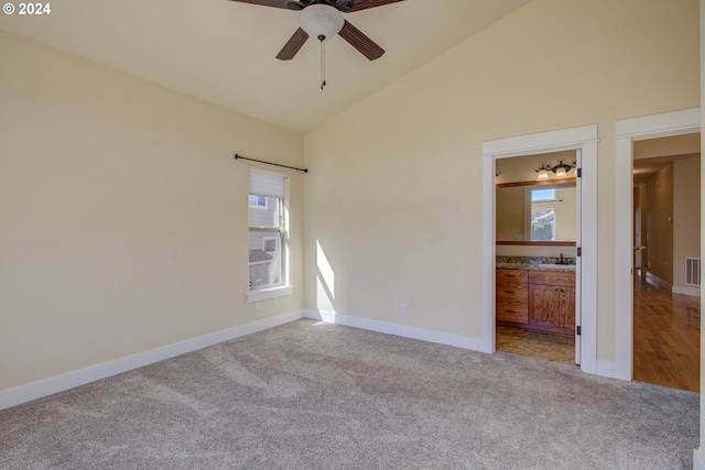 empty room featuring a wealth of natural light, ceiling fan, and light carpet