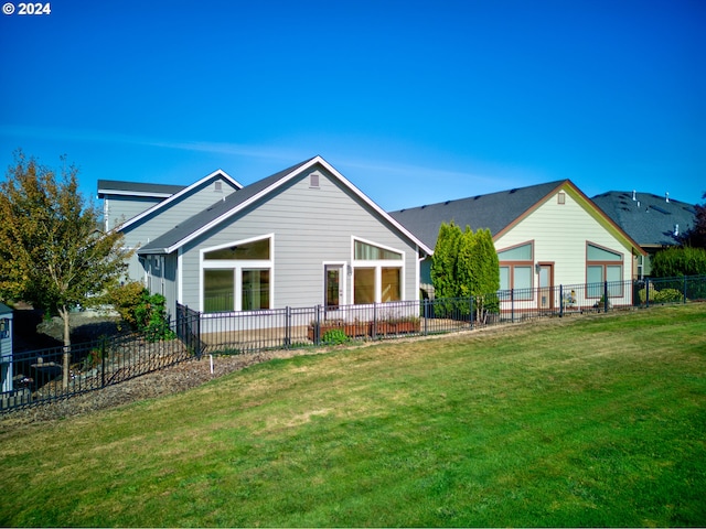 rear view of property featuring a lawn and a garage