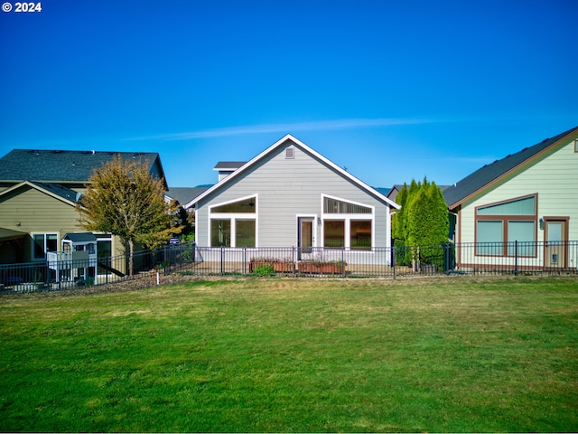 rear view of house featuring a yard