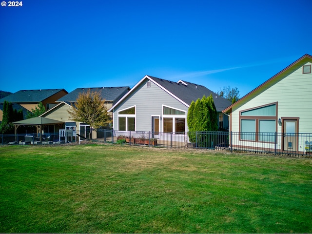 rear view of house featuring a yard