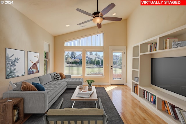 living room with high vaulted ceiling, light hardwood / wood-style flooring, and ceiling fan