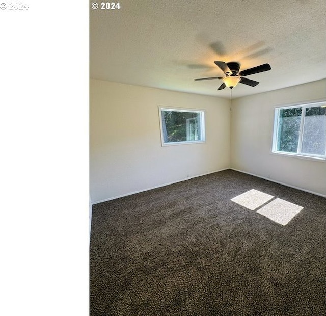 carpeted empty room featuring ceiling fan and a textured ceiling