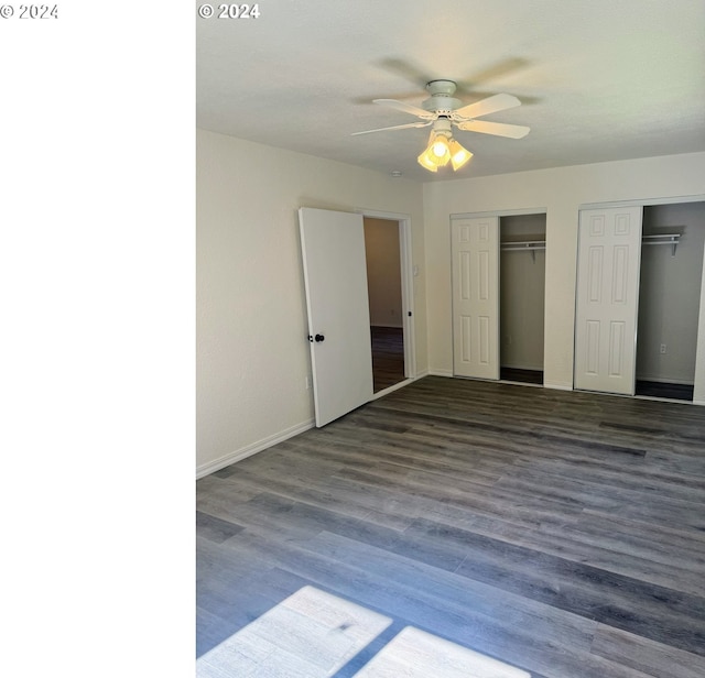 unfurnished bedroom with ceiling fan and dark wood-type flooring