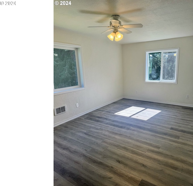 unfurnished room with ceiling fan, dark hardwood / wood-style flooring, and a textured ceiling