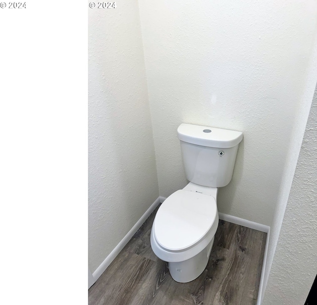 bathroom with hardwood / wood-style flooring and toilet