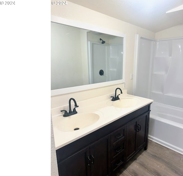 bathroom with hardwood / wood-style flooring, vanity, and shower / bath combination