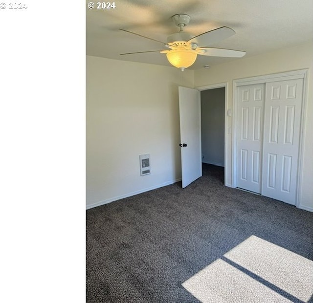 unfurnished bedroom with ceiling fan, a closet, and dark colored carpet