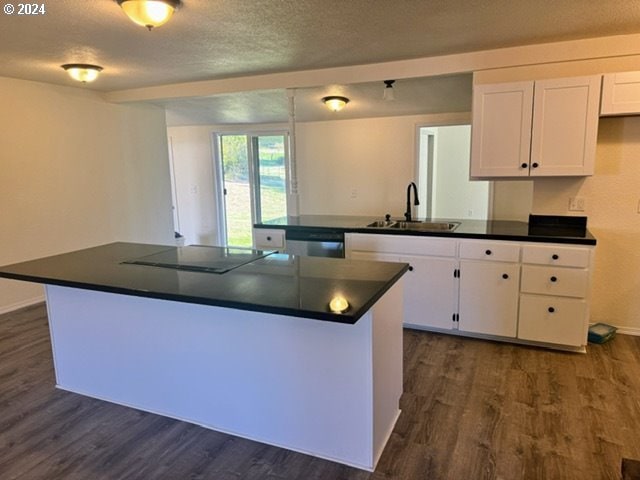 kitchen featuring black electric stovetop, sink, dishwashing machine, dark hardwood / wood-style flooring, and white cabinetry